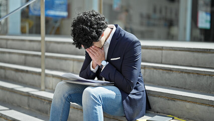 Obraz premium Young latin man business worker reading document stressed at street