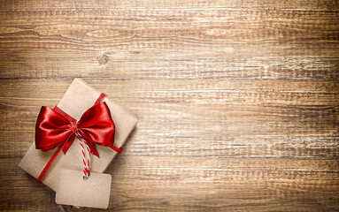 one gift in a craft package with a red silk bow is on the table. space for text