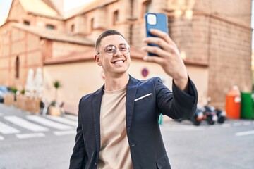 Young hispanic man executive smiling confident make selfie by smartphone at street