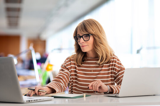 Blond haired businesswoman using laptops for work at the office