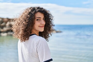 Young hispanic woman smiling confident standing at seaside