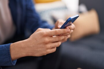 Young caucasian man using smartphone at home