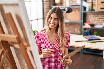Young woman artist smiling confident drawing at art studio