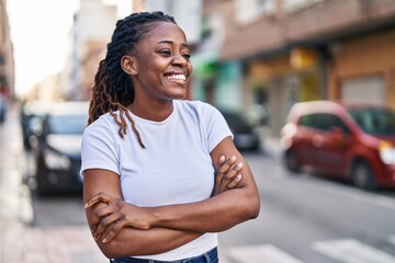 African american woman standing with arms crossed gesture at street - obrazy, fototapety, plakaty