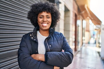 African american woman standing with arms crossed gesture at street