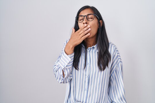 Young hispanic woman wearing glasses bored yawning tired covering mouth with hand. restless and sleepiness.