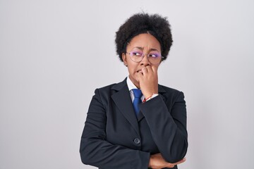Beautiful african woman with curly hair wearing business jacket and glasses looking stressed and...