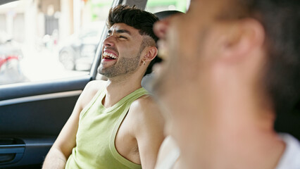Two men couple smiling confident driving car speaking at street