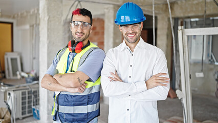 Two men builder and architect smiling confident standing with arms crossed gesture at construction...