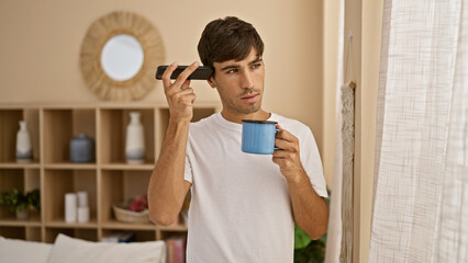 Handsome young hispanic man relaxing in morning pyjamas, deeply engrossed in listening to a...