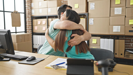 Two coworkers agreeing with a hug at ecommerce office