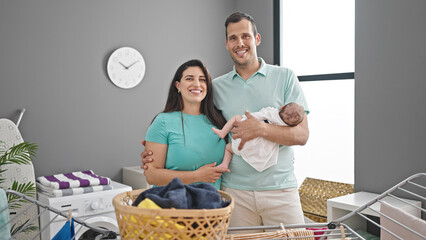 Family of three hanging clothes on clothesline at laundry room