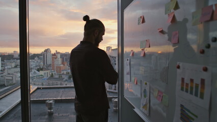 Businessman silhouette thinking notes evening office. Specialist reading tasks