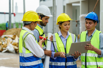 Construction workers talking together looking at laptop in Site
