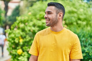 Naklejka na ściany i meble Young hispanic man smiling confident looking to the side at park