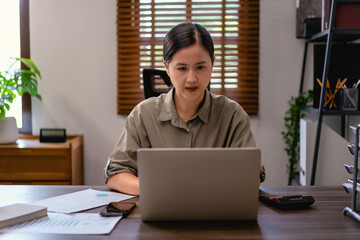 Casual business women typing data on laptop while thinking and analysis about marketing strategy