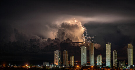 Impressive lightning strikes high-rise buildings in dark city storm