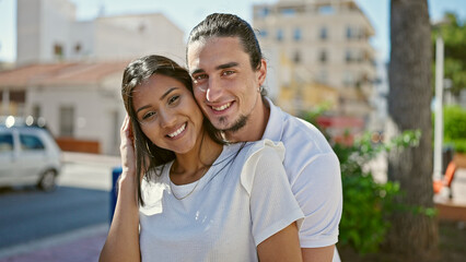 Man and woman couple smiling confident hugging each other at street