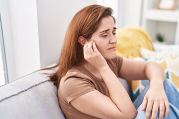 Obraz premium Young woman suffering for ear pain at home