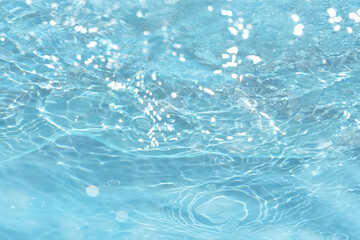 Water splash in the glass. bubbles in water. Blue water with ripples on the surface. Defocus...
