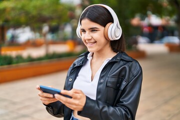 Young beautiful hispanic woman smiling confident listening to music at park