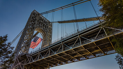 Low angle view of  a huge American Flag hanging from the west tower of the George Washington Bridge on a sunny day.