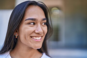 Fototapeta premium Young beautiful hispanic woman smiling confident looking to the side at street