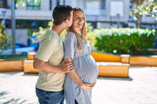 Man and woman couple hugging each other expecting baby at park