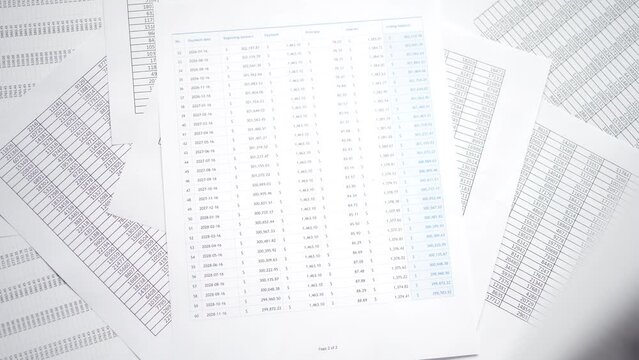 Accountant With Many Different Spreadsheet Pages on a Desk