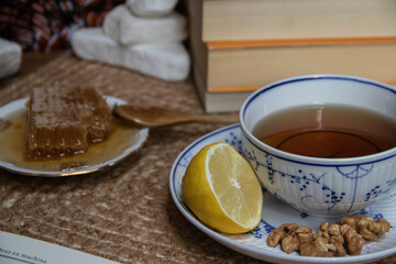 Picture of young woman enjoying quiet morning time at balcony with nice view on small city park, having a tea with organic honey and few fruits from organic farm