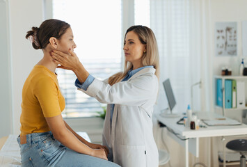 Doctor examining lymp nodes on neck of the teenage girl. Palpation of lymph nodes. Concept of...