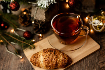 Croissant and tea. Pastries for Christmas. Fast food during the winter holidays