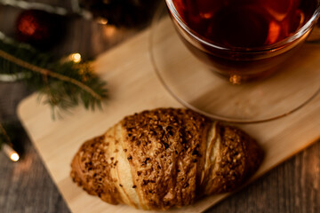 Cup of tea with croissant near Christmas tree.New Year's Eve at home with family