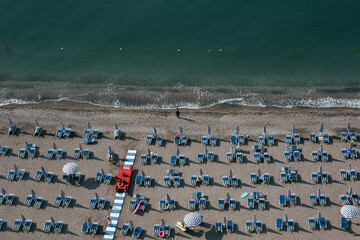 Amalfi Sea Coast with Umbrellas, people swim, and Yachts. Clean and blue sea where to swim. Photo for tourism and summer background. Concept of vacation and beach life in the open air