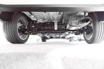 Rear car suspension and exhaust pipe