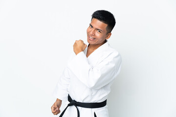 Young Ecuadorian man doing karate isolated on white background celebrating a victory