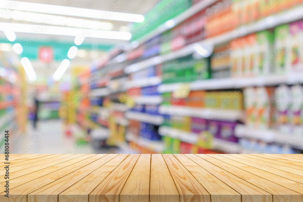 Wall mural empty wood table top with supermarket blurred background for product display