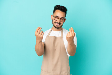 Fototapeta premium Restaurant waiter caucasian man isolated on blue background making money gesture