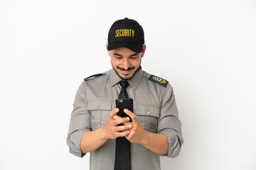 Young security  caucasian man isolated on white background sending a message with the mobile
