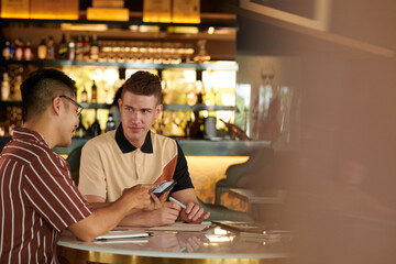 Young man discussing investing strategy with his business partner during lunch break