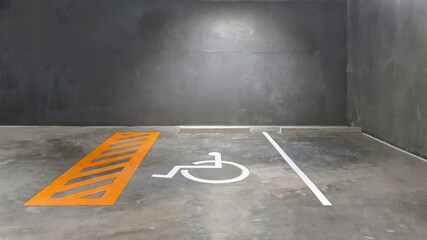 Reserve parking lot for disabled at modern building basement, international symbol or universal sign for handicapped parking painted on the concrete floor - obrazy, fototapety, plakaty