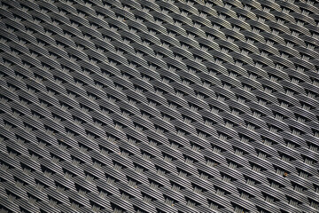 Black background made of plastic-like material
with criss-cross meshes. Dark monochromatic
texture and formed by straight lines.
