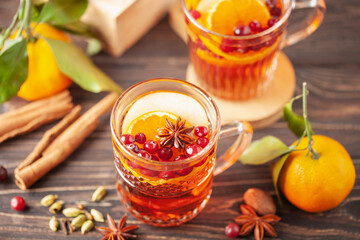 Homemade hot alcohol cranberry orange apple cider punch with cinnamon sticks, anise star and...