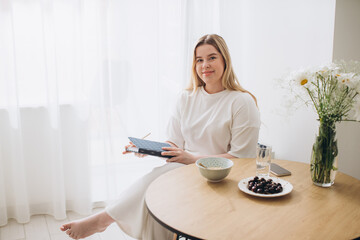 Young beautiful female student at home doing creative journal.