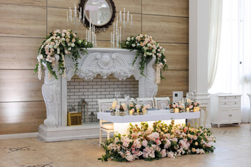 Naklejka premium Wedding ceremony. Presidium for the newlyweds, decorated with candles and vases with white and pink natural flowers such as eustoma, hydrangea, roses. Floristic concept