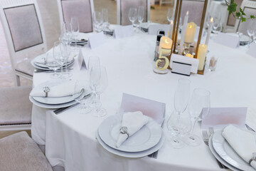 Wedding decorations. Served wedding table with decorative  white napkins, envelopes and candles. Celebration details