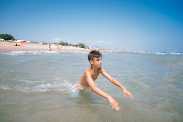 Teenage girl enjoying a fabulous day at the beach. She bathes in the sea.