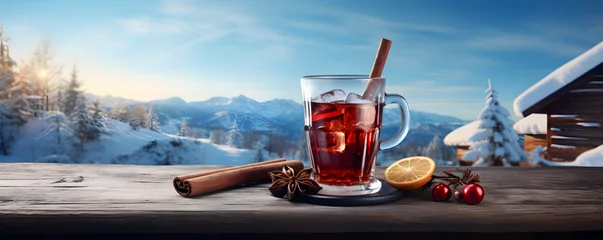 Fotobehang Mulled red wine with cinnamon in a glass on an old rustic wooden plank with a winter landscape in the background, © ELmahdi-AI
