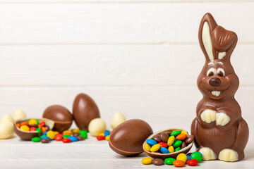 Easter chocolate bunny on a light texture table. Chocolate eggs and other sweets. Easter celebration concept. Easter sweets on the table. Place for text. copy space.
