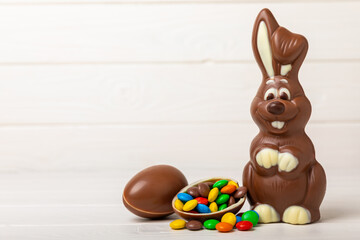 Easter chocolate bunny on a light texture table. Chocolate eggs and other sweets. Easter celebration concept. Easter sweets on the table. Place for text. copy space.